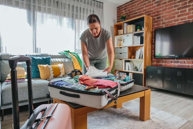 Long term storage Brighton. Image shows a woman packing her suitcases in the living room.