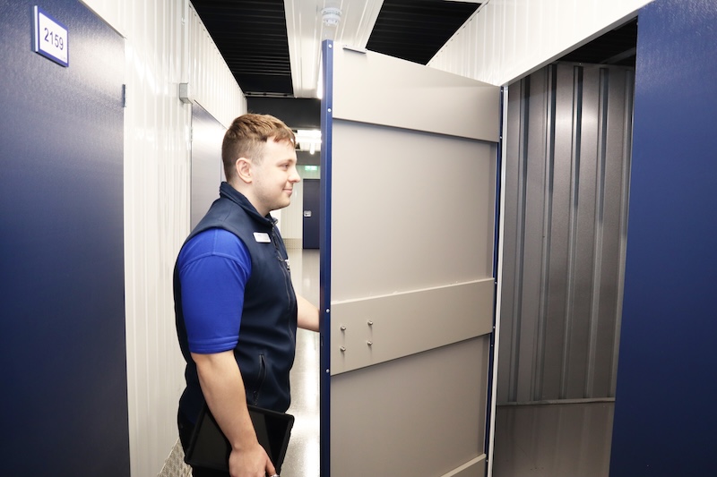 Small storage Earlsfield. Image shows Cinch Storage employee opening the door to a storage unit.