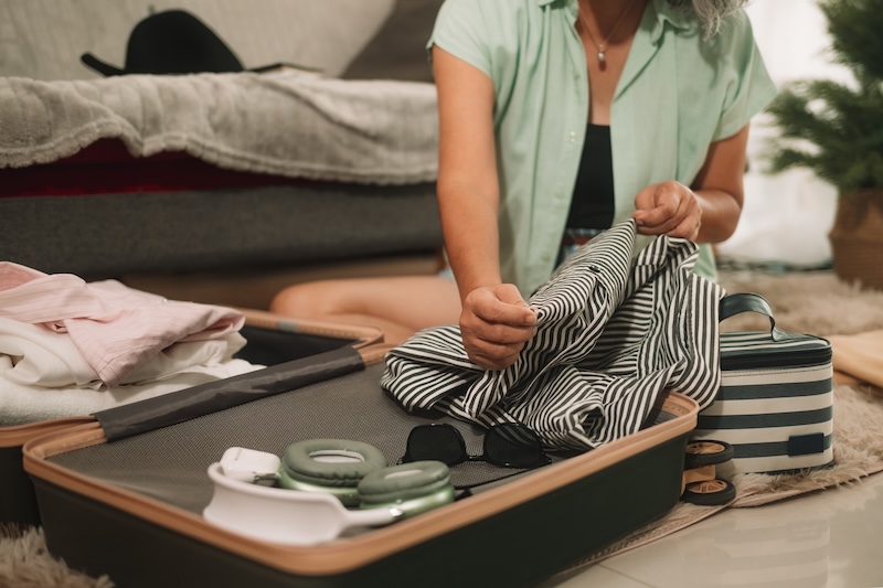 Low cost storage Enfield. Image shows a woman packing up her suitcase ready for travelling.
