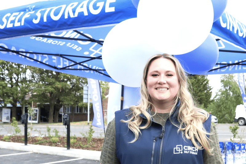 Low cost storage Southend. Image shows a Cinch Storage employee standing in front of a marquee with balloons.