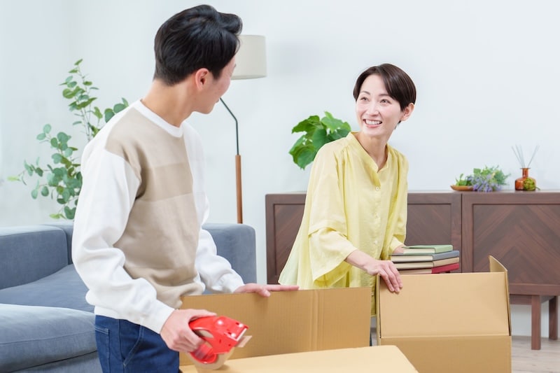 House move storage Newcastle. Image shows a young couple packing cardboard boxes ready to move house.