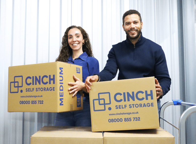 Storage in Paulton. Image shows a couple unloading Cinch Self Storage cardboard boxes into their storage unit.