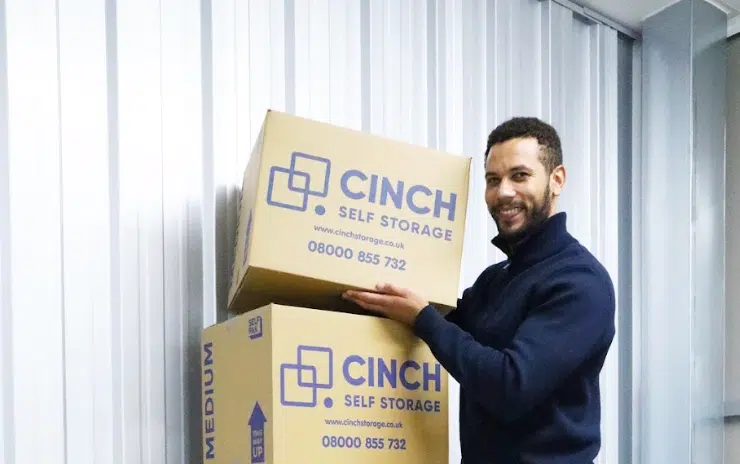 Storage units Shoreham. Image shows a man stacking Cinch Self Storage cardboard boxes in his spacious storage unit.