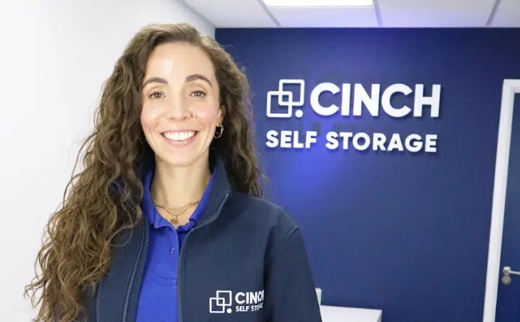 Cinch Storage Watford. Image shows a cinch storage employee standing infront of the cinch storage logo.