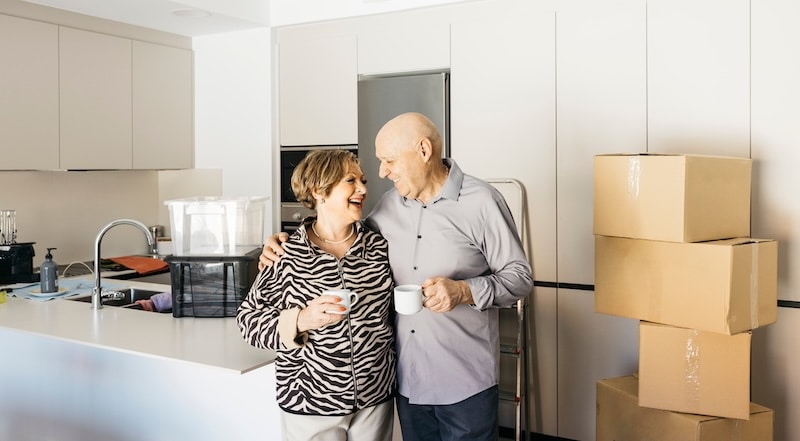 Storage facilities Paulton. Image shows a senior couple embracing and drinking coffee, celebrating moving into their new home.