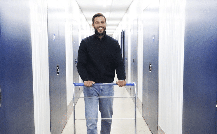 Ultimate guide to self storage in Watford. Image shows a man with an empty trolley in the corridor of Cinch Self Storage Watford.