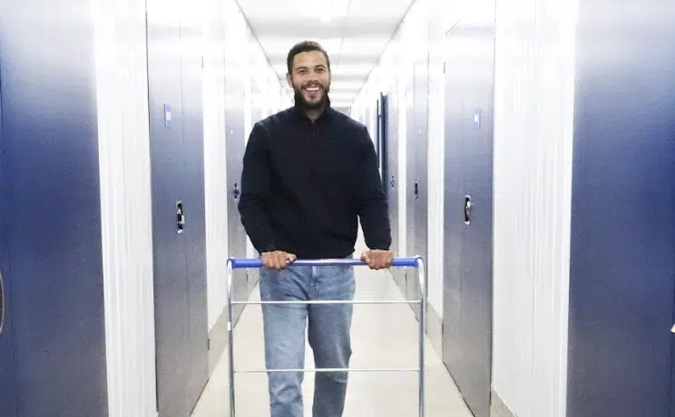 Ultimate guide to self storage in Watford. Image shows a man with an empty trolley in the corridor of Cinch Self Storage Watford.