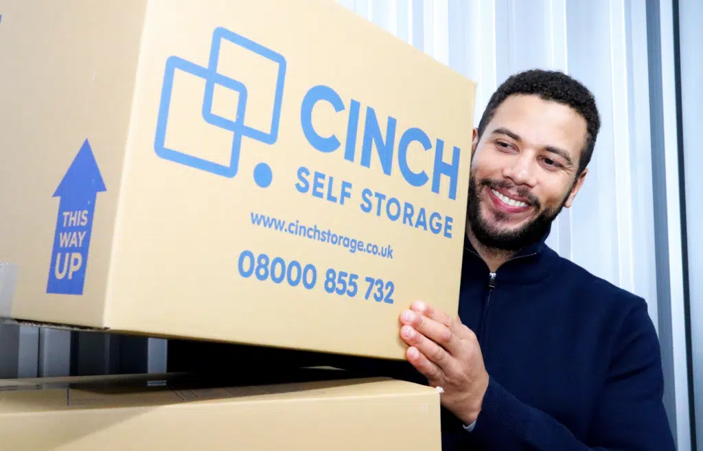 House move storage Shoreham-by-Sea. Image shows a man moving house stacking boxes in his storage unit.