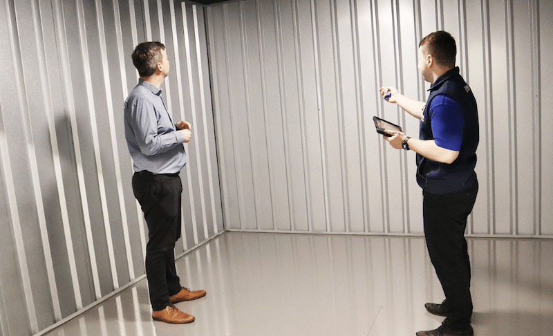 Storage rooms Watford. Image shows a Cinch Storage employee showing a customer around a storage room.