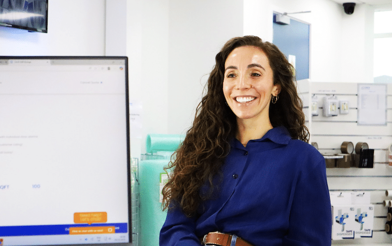 Long term storage Shoreham. Image shows a woman smiling sitting in a Cinch Self Storage reception. 