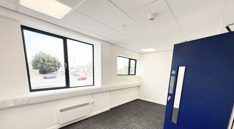 Office to rent Enfield. Image shows a new empty office at Cinch Self Storage. With a large window and carpeted floors. 